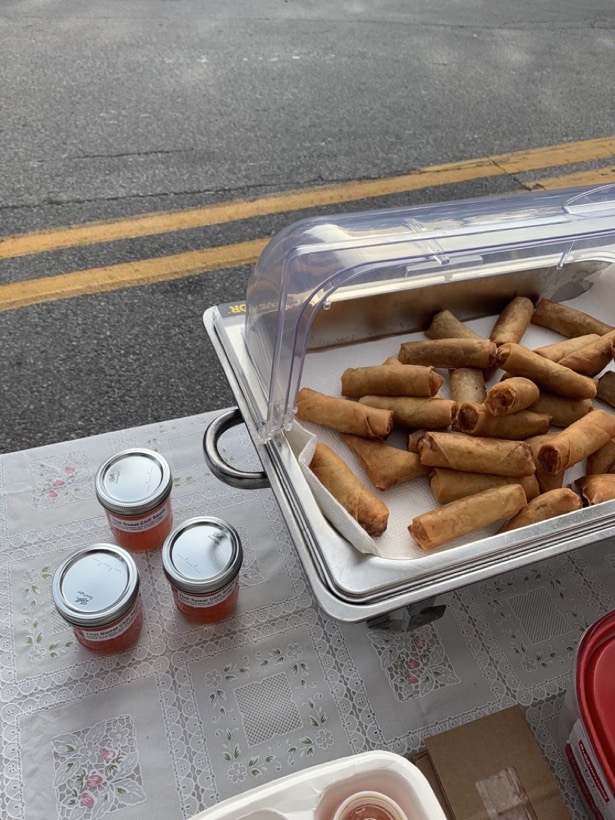 A tray of egg rolls and jars of Thai sweet chili sauce at the farmers market
