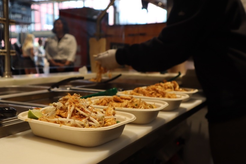 Boxes of pad thai being served across the counter